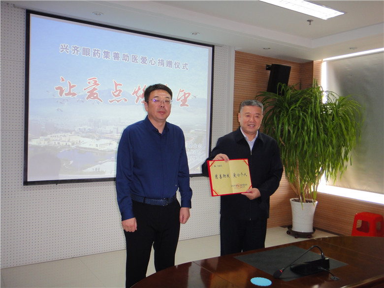 市残联副理事长刘佶向沈阳兴齐眼药股份有限公司董事长刘继东颁发荣誉